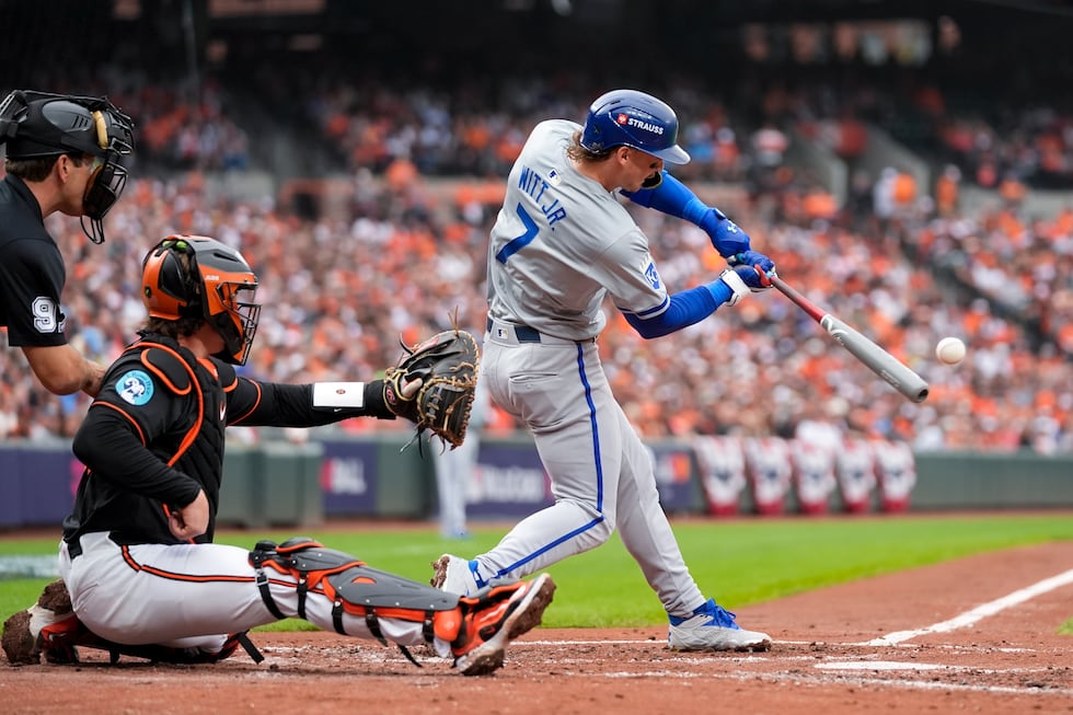 Kansas City Royals' Bobby Witt Jr. (7) hits a single as home plate umpire Ben May, left, and...