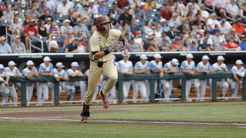 Florida State's Drew Faurot legs out a hit to first base at the College World Series. The...